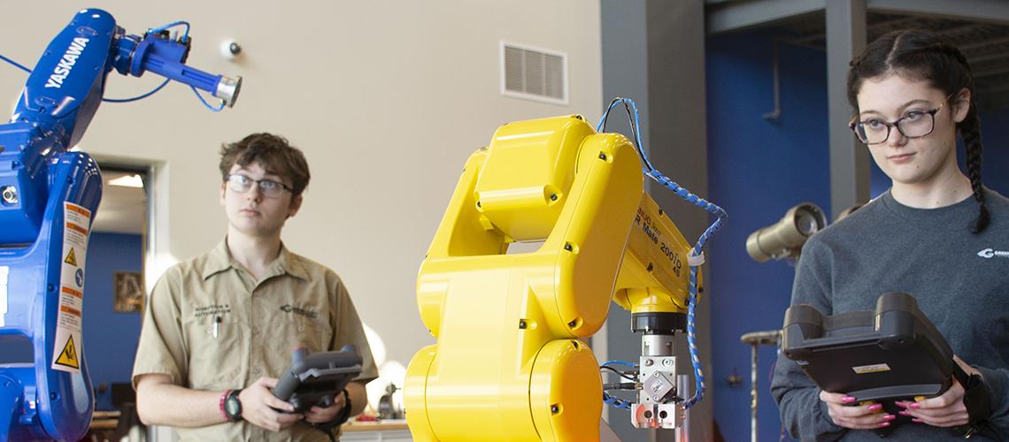 Greene County Career Center students operate two robotic machines used in manufacturing.